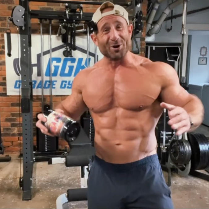 Muscular man in a gym holding a protein shake, with 'GGG' Garage Gym logo in the background.